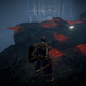 A fantasy warrior stares at a dark cave ledge covered in bloodstains.